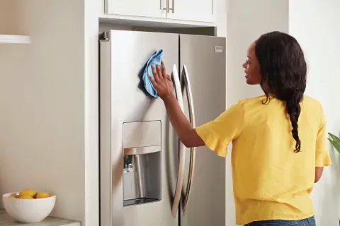 woman-wiping-down-refrigerator-exterior-frigidaire-gallery